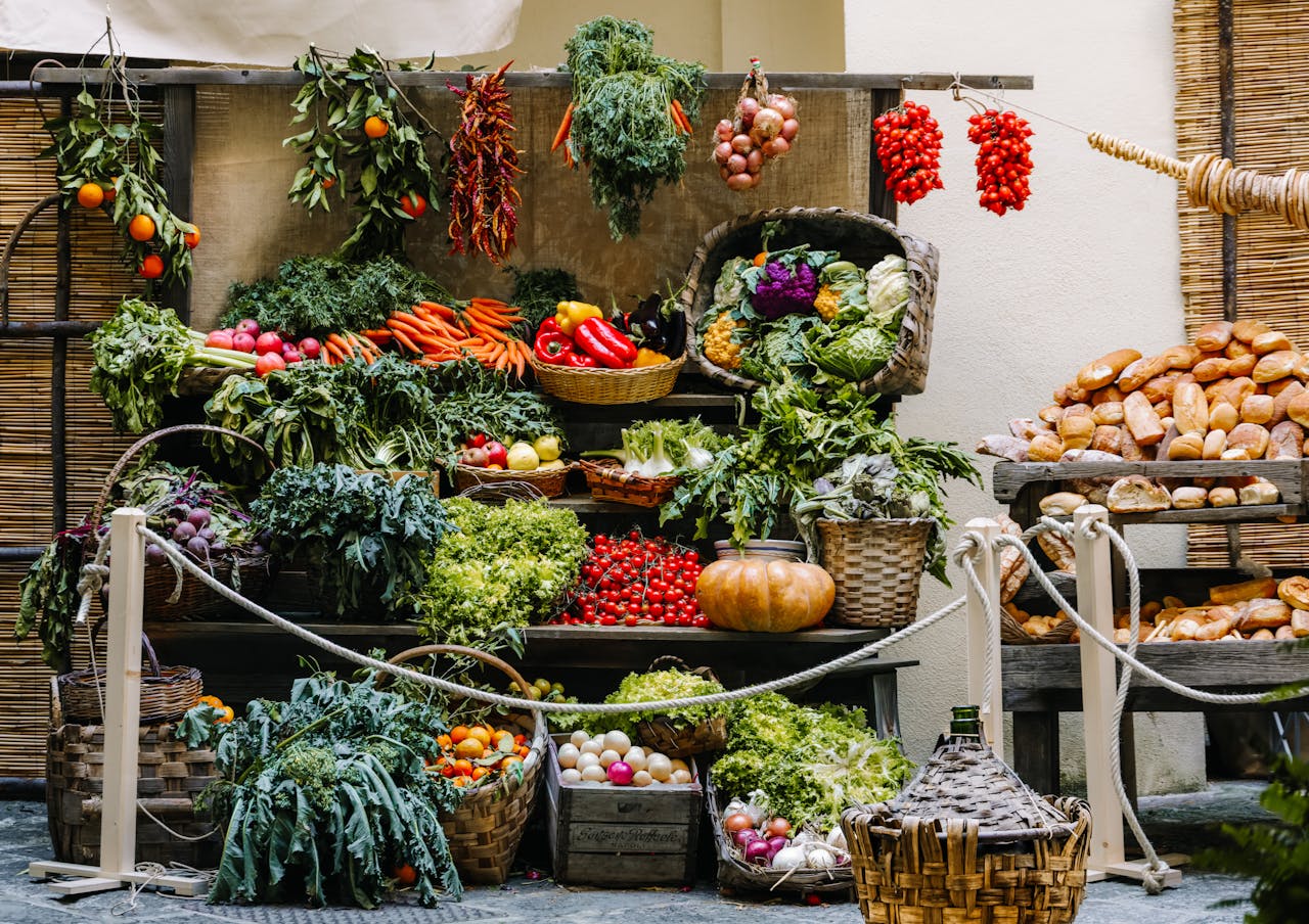 Vibrant array of fresh produce and bread at a farmer's market stand, showcasing seasonal vegetables and baked goods.